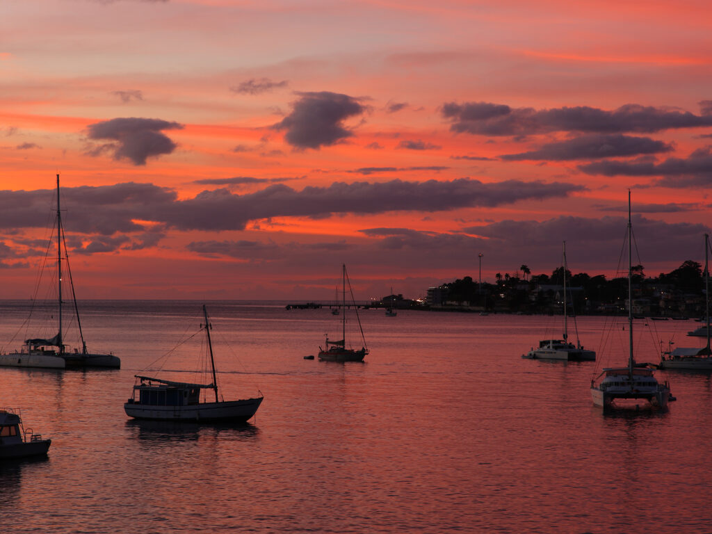 Sunset over ocean on Dominica in the Caribbean with red sky in background