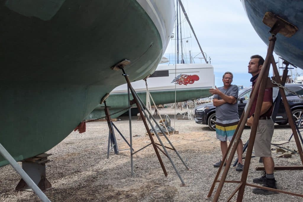 two men looking at a sailboat